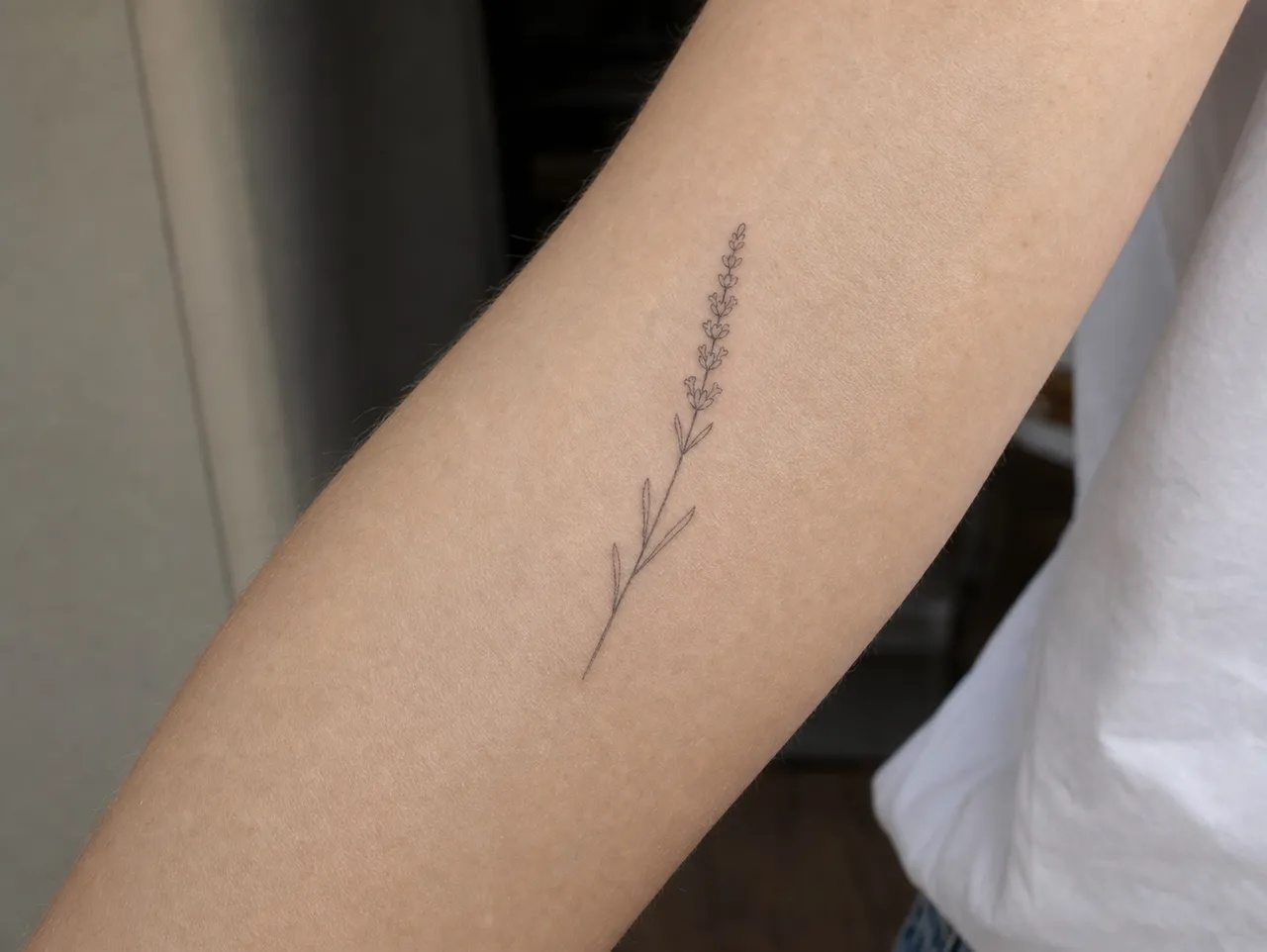 Fine line botanical tattoo healed at six months on outer forearm